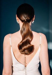 Brunette woman with her hair styled in a long, glossy ponytail